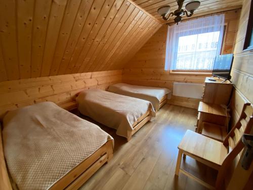 NowicaNowica 71 Relax Dom Świerkowy的木制客房内的一间卧室配有两张床