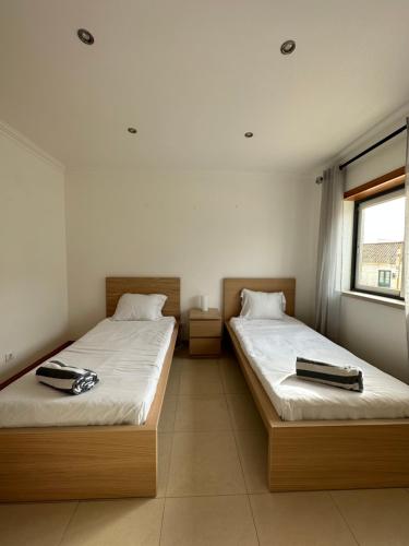 费雷尔Ocean Guesthouse Baleal的两张睡床彼此相邻,位于一个房间里
