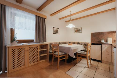 科瓦拉因巴迪亚Residence Chalet Pinis的厨房以及带桌椅的用餐室。