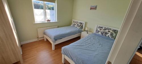 波特马吉Gort Lodge的一间卧室设有两张床和窗户。