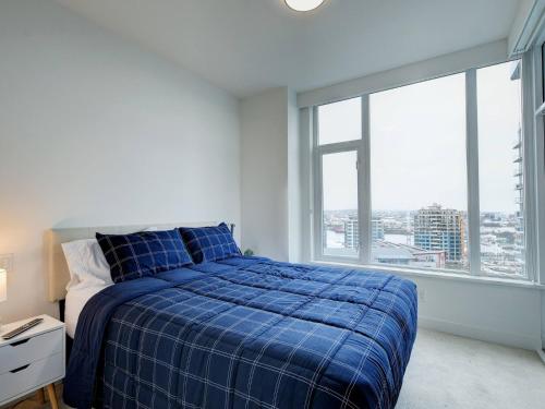 维多利亚Admiral's Anchor by IRIS PROPERTIES!的一间卧室设有蓝色的床和大窗户