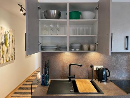 沃尔姆斯Traumhaft helle Wohnung mit Sonnenterrasse的厨房配有水槽、盘子和玻璃杯