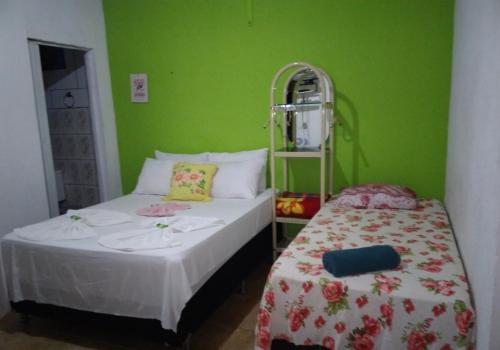 圣安娜杜里亚舒Pousada Central的绿墙客房内的两张床