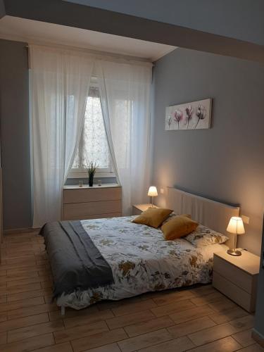 佛罗伦萨Appartamento vicino aeroporto的一间卧室配有一张带两盏灯的床和一扇窗户。