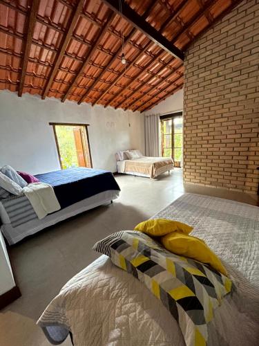 帕尔梅拉斯Casa Mirante do Capão的一间卧室设有两张床和砖墙