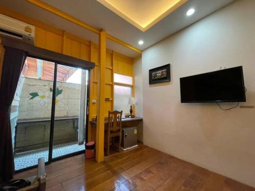大城tamarind guesthouse的客厅的墙上配有平面电视。