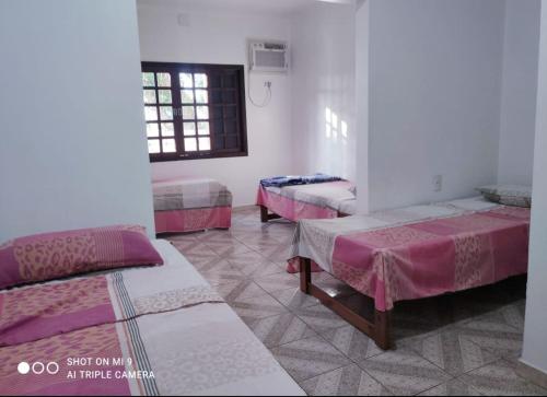 伊瓜苏Hostel Beija flor的带三张床和窗户的客房
