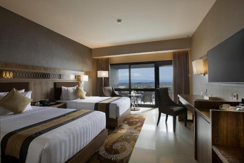 日惹日惹爱慕卡摩皇家酒店的酒店客房设有两张床、一张书桌和一个厨房。