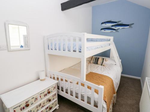 滕比Bluebell Cottage的儿童卧室配有双层床和双层床