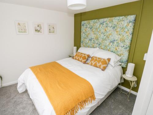 滕比Rosemary Cottage的一间卧室配有一张带橙色毯子的床
