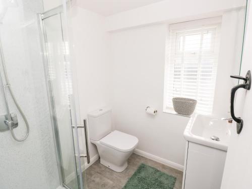 滕比Rosemary Cottage的白色的浴室设有卫生间和水槽。