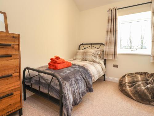 普雷斯顿The Byre的一间卧室配有一张带橙色毛巾的床
