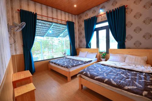 大叻Cẩm Tú Villa Đà Lạt的一间卧室设有两张床和窗户。