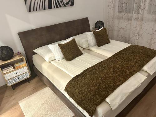 埃本塞Unterschlupf的一张大床,配有棕色和白色的床单和枕头