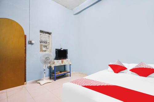巴都安帕SPOT ON 92072 Restu Ibu Homestay Syariah的一间卧室配有红色和白色枕头的床
