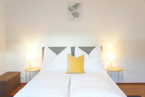 蓬高地区施瓦察赫Schwarzacherhof Pension & Apartments的一间卧室配有白色床和黄色枕头
