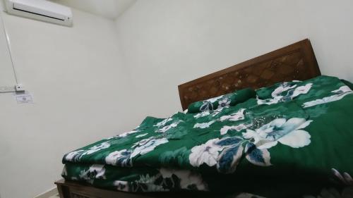 乌鲁地南Zulaikha's Homestay Ulu Tiram Johor Bahru的一张带绿毯的床,上面有白色的花朵