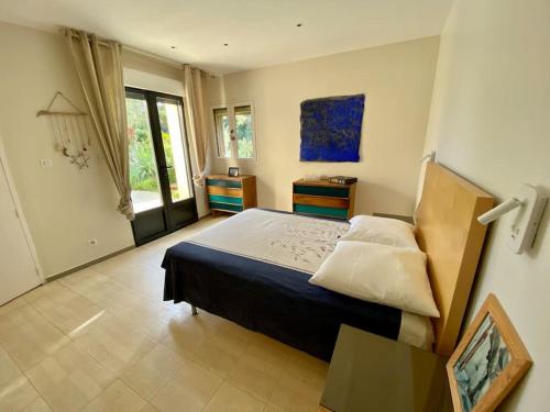 耶尔villa d'exception avec piscine , au bord de la mer的一间卧室设有一张大床和一个窗户。