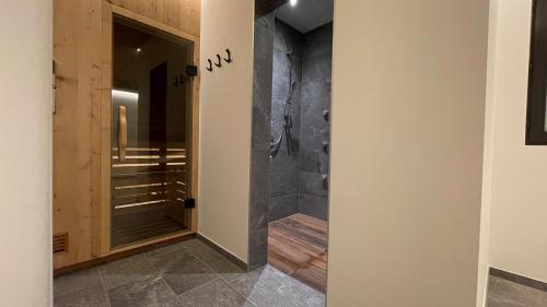 圣洛伦佐-迪塞巴托Residence Tantalus的浴室设有步入式淋浴间,位于玻璃门旁