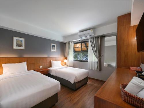 清迈清迈伊斯提亚酒店-SHA Plus的酒店客房设有两张床和窗户。