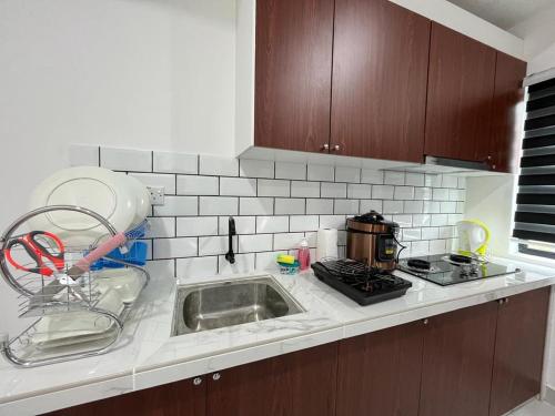 新邦安拨Surestay homestay的厨房柜台设有水槽和炉灶。