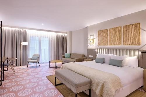 格拉纳达Boutique Hotel Luna Granada Centro的酒店客房设有一张大床和一间客厅。