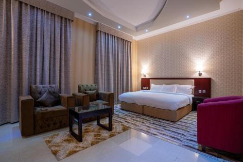 迪拜Vista City Hotel的酒店客房,配有一张床和两把椅子