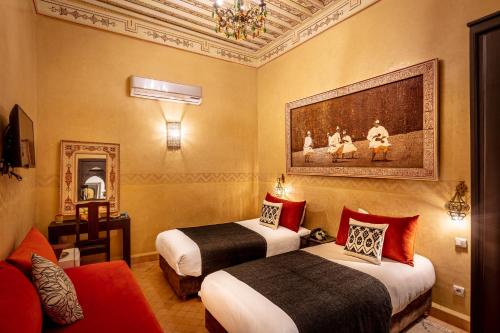 马拉喀什里亚德水疗巴伊亚萨拉姆酒店的酒店客房设有两张床,墙上挂有绘画作品