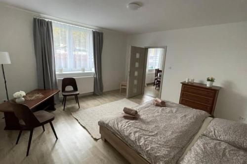莫斯特Dům nad Jezerem - apartmán I.的一间卧室配有一张床、一张桌子和一张桌子