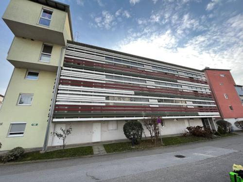 格拉茨Apartment in einer ruhigen Umgebung in Graz的白色的大建筑,设有红色和白色的窗户