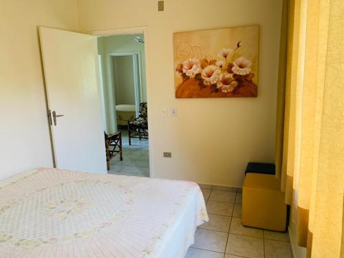 圣代佩德罗Aguas de São Pedro ambiente Familiar e Aconchegante的卧室配有一张床,墙上挂有绘画作品