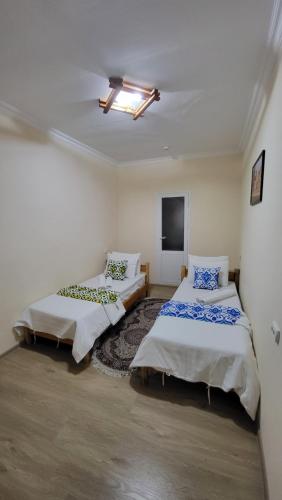 撒马尔罕Alisher B&B Hotel的一间设有两张床和一台电视的房间