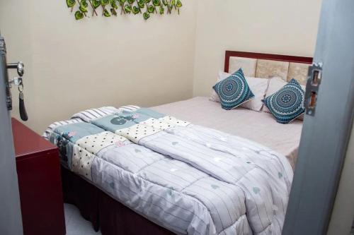 姆万扎Hotel Kingdom Appartments的一间卧室配有一张带蓝色枕头的床