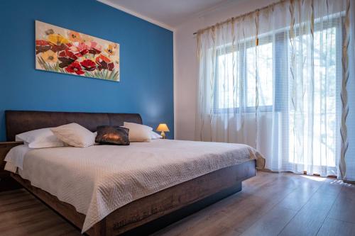 BiskoVilla Breeze - perfect getaway in untouched nature的一间卧室配有一张蓝色墙壁和窗户的床