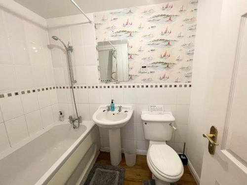 威灵堡Wilce House的浴室配有盥洗盆、卫生间和浴缸。