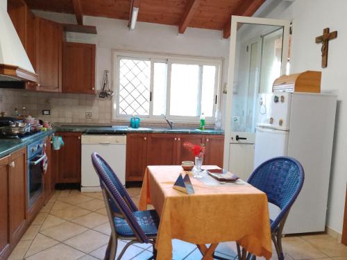 切萨雷奥港Cosy Residenze的厨房配有桌椅和白色冰箱。