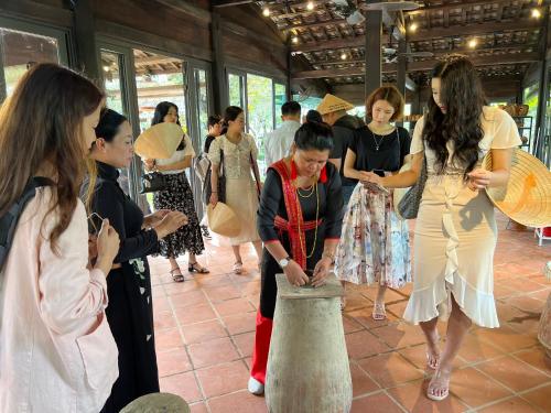 芽庄Champa Island Nha Trang - Resort Hotel & Spa的一群妇女站在花瓶周围