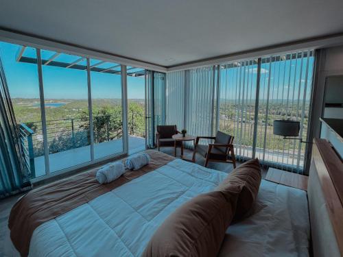 Juana Koslay Altos de Los Paraísos Vista al lago y sierras的一间卧室设有一张大床和大窗户