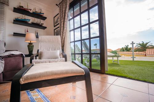 卡亚俄萨尔瓦赫5 bedrooms villa La Laja的客厅配有椅子和大窗户