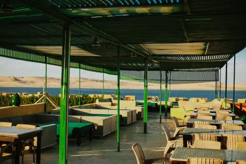 Qaryat at Ta‘mīr as SiyāḩīyahLake House by Tunisia Green Resort的一间带桌椅的海景餐厅