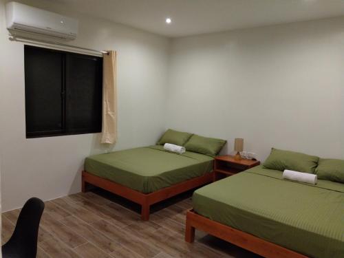 巴迪安SBG Resort Lambug的小房间设有两张床和窗户