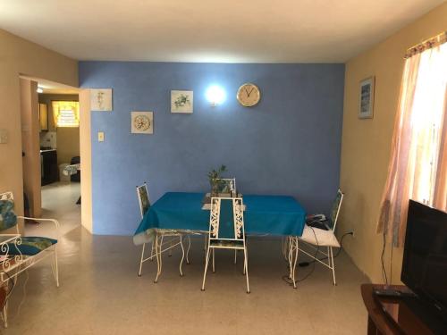 布里奇敦DonaMae 2 story Barbados House的蓝色墙壁的房间里一张桌子和椅子