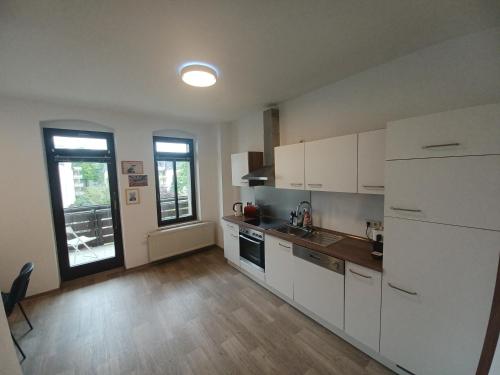 茨维考L118 Vermietungen的厨房配有白色橱柜、水槽和窗户。