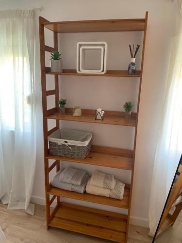 格拉纳达acogedor apartamento 2 dormitorios的木书架、电视和毛巾