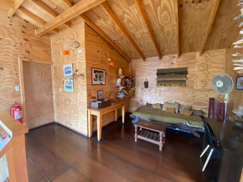 卡斯特鲁Hostal Palafito Waiwen的小木屋内的一个房间,配有沙发和一张书桌