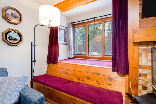 威尔森3614 Winterberry的客房设有带紫色窗帘和长凳的窗户。