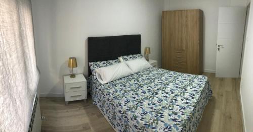 萨莫拉PARQUE DE LA MARINA ESPAÑOLA的一间卧室配有一张带蓝色和白色棉被的床