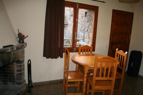 努奇堡Cal Xesc的窗户客房内的一张木桌和椅子