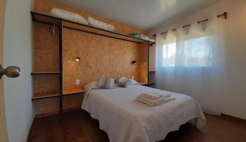 拉帕洛马ALMA VERDE BUNGALOWS的一间卧室配有带毛巾的床