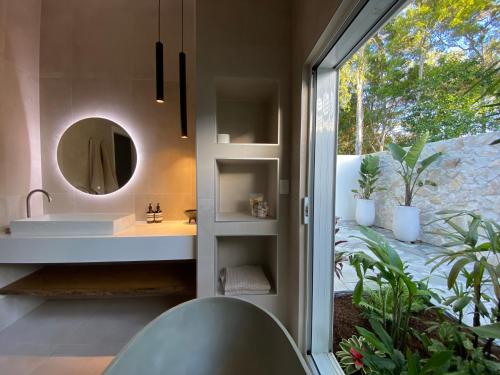 麦夸里港Tallowwood House Luxury Bed & Breakfast的一间带水槽和镜子的浴室